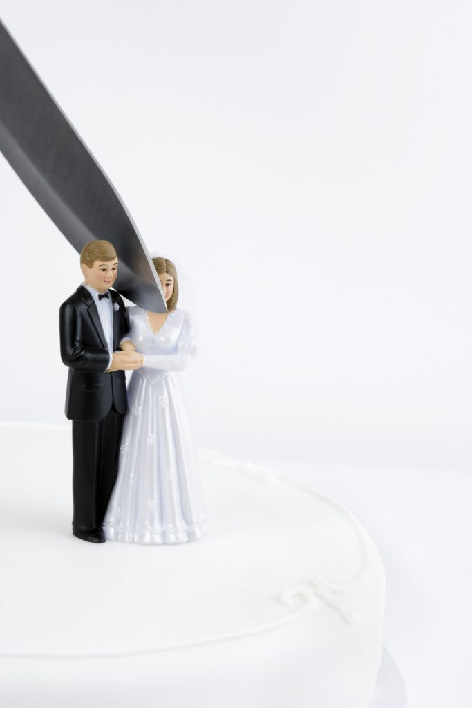 knife-cutting-through-bride-and-groom-on-wedding-cake-2289594-683x1024